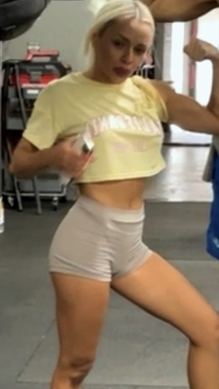 Ashlyn before: yellow crop top, flexing in the gym